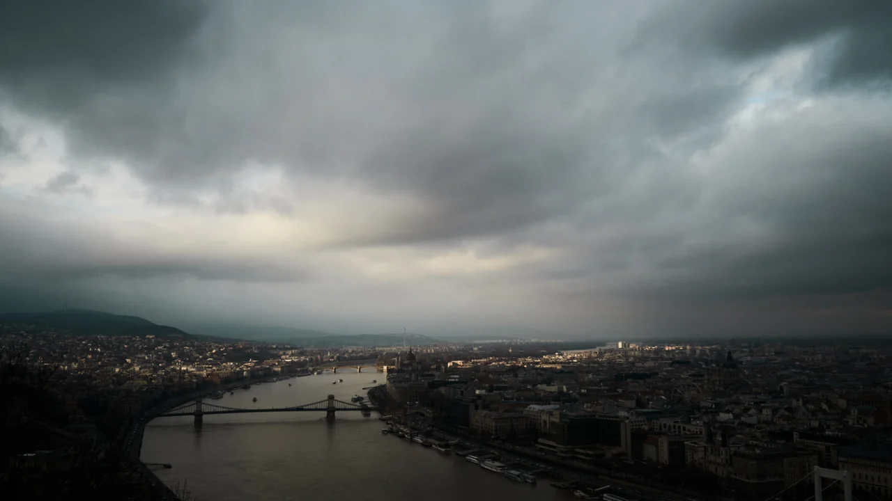 Vista aérea de uma cidade sob nuvens escuras de tempestade no fim da tarde, com o céu carregado sobre os prédios