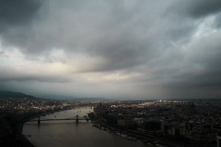 Vista aérea de uma cidade sob nuvens escuras de tempestade no fim da tarde, com o céu carregado sobre os prédios