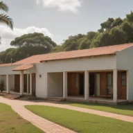 Casa residencial de um andar com jardim, calçada de tijolos e árvores ao redor, em dia claro