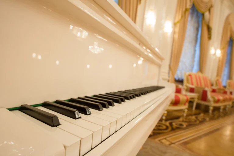 Teclado de um piano branco em um salão, em fotografia de banco.