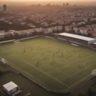 Complexo esportivo de bairro em Bragança Paulista ao amanhecer, com campo society, alambrados e quadra, sem pessoas.