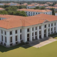 Fachada de prédio público municipal com colunas brancas e escadaria, vista da calçada