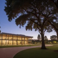 Campus de inovação com edifício envidraçado, jardins e árvores ao amanhecer