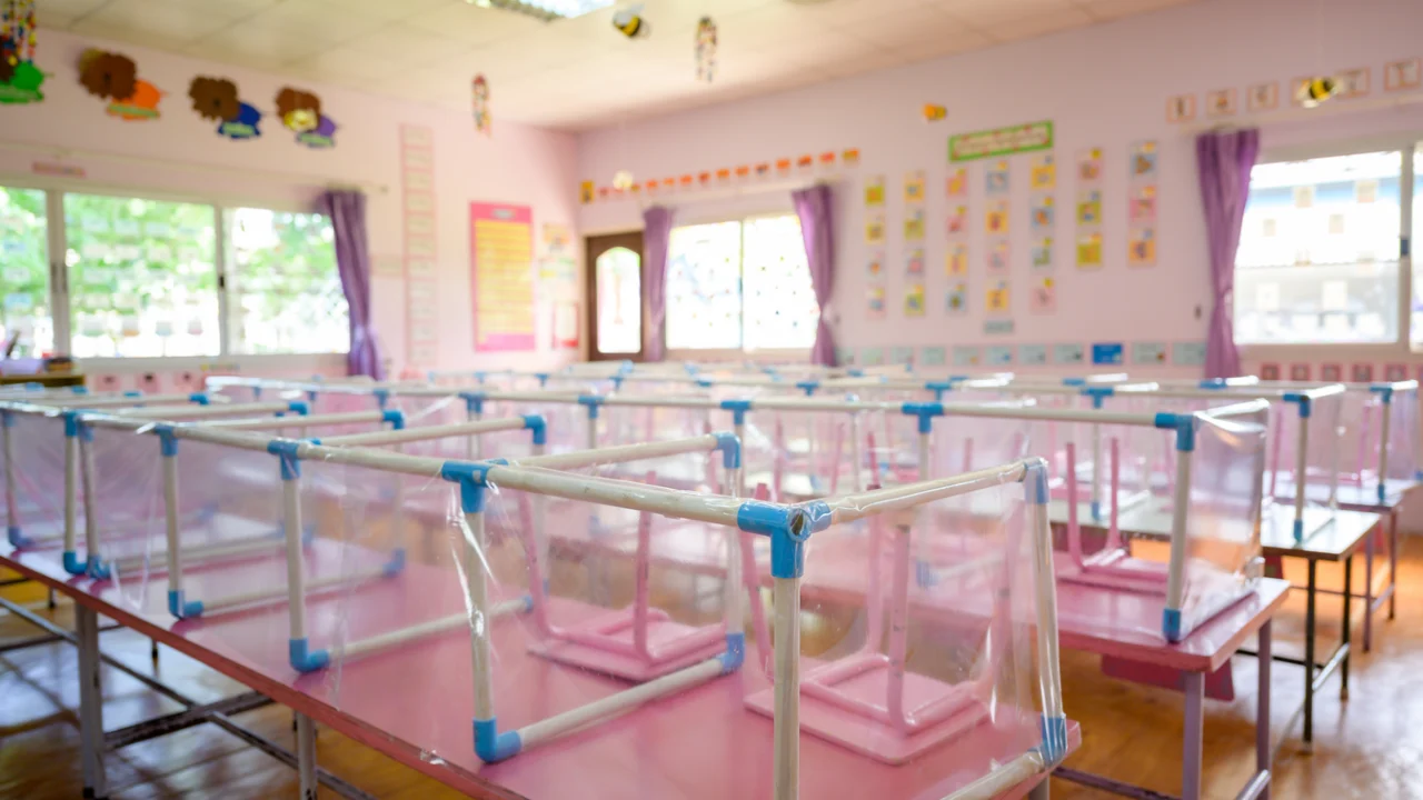 Sala de creche municipal com berços, mesinhas coloridas e cartazes infantis nas paredes