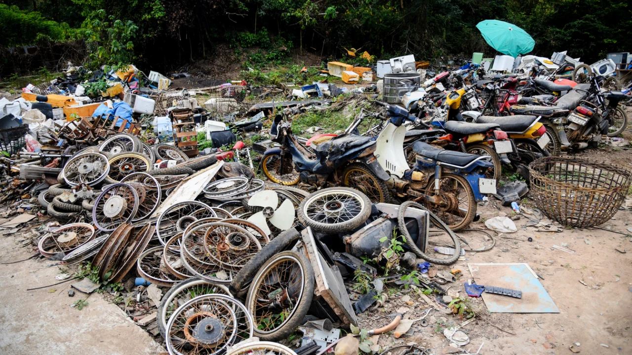 Rodas e peças de motocicletas desmontadas acumuladas em um terreno