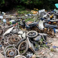 Rodas e peças de motocicletas desmontadas acumuladas em um terreno