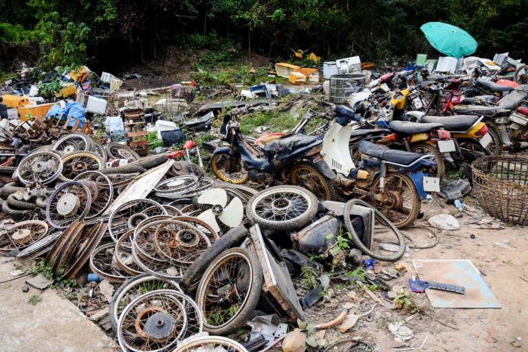 Rodas e peças de motocicletas desmontadas acumuladas em um terreno