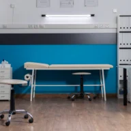 Sala de atendimento de enfermagem com maca e equipamentos em unidade pública de saúde