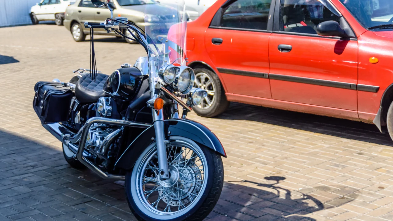 Moto estacionada na calçada de uma rua movimentada de centro urbano