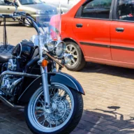 Moto estacionada na calçada de uma rua movimentada de centro urbano