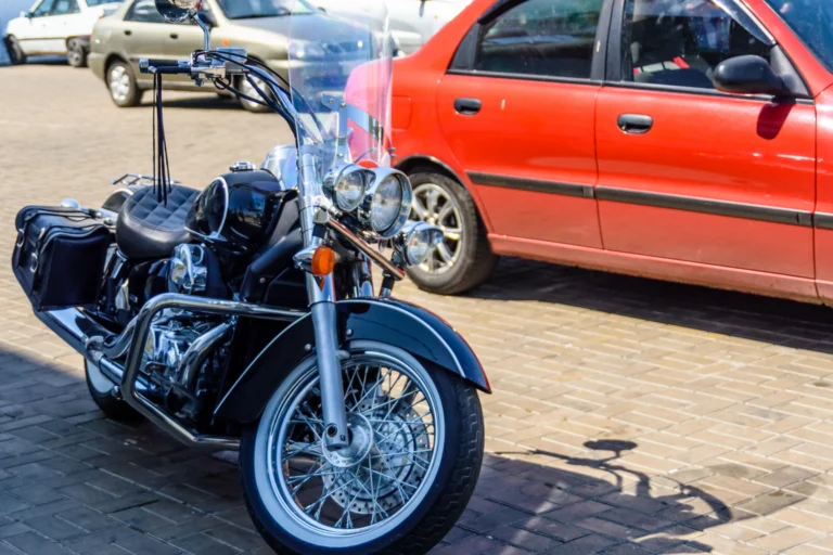 Moto estacionada na calçada de uma rua movimentada de centro urbano
