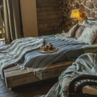 Quarto de pousada com cama de casal arrumada, móveis de madeira e luz natural entrando pela janela