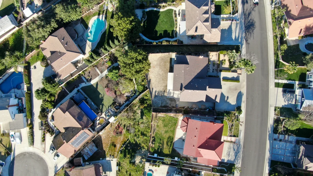 Vista aérea de um bairro residencial com casas baixas e ruas arborizadas
