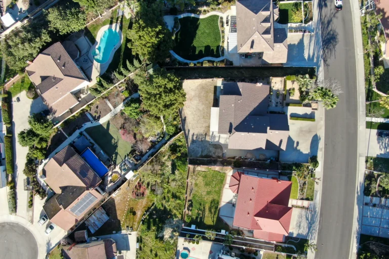 Vista aérea de um bairro residencial com casas baixas e ruas arborizadas