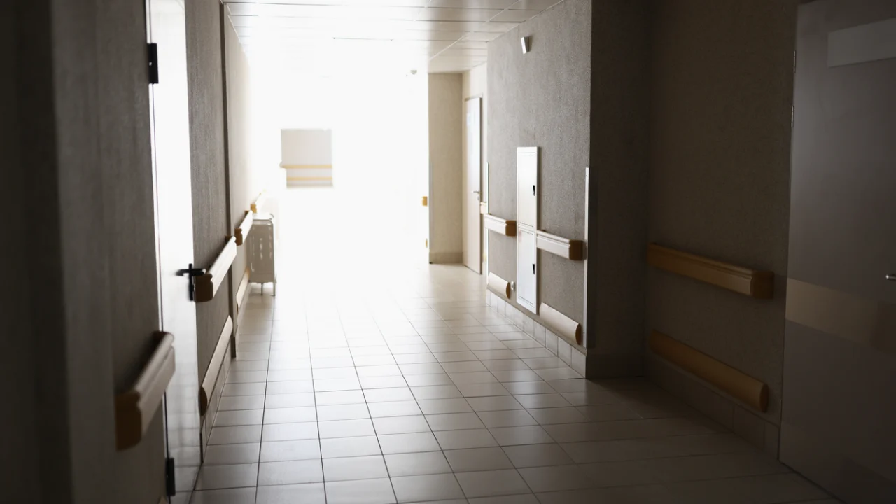 Corredor claro de unidade hospitalar, com corrimãos e piso de cerâmica