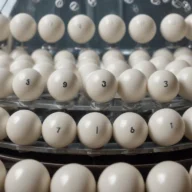 Esferas numeradas de sorteio em um globo de acrílico sob luz de estúdio