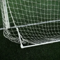 Rede de gol de campo de futebol com gramado aparado e linha branca demarcando a área