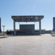 Palco de eventos ao ar livre vazio, com estrutura metálica e refletores apagados
