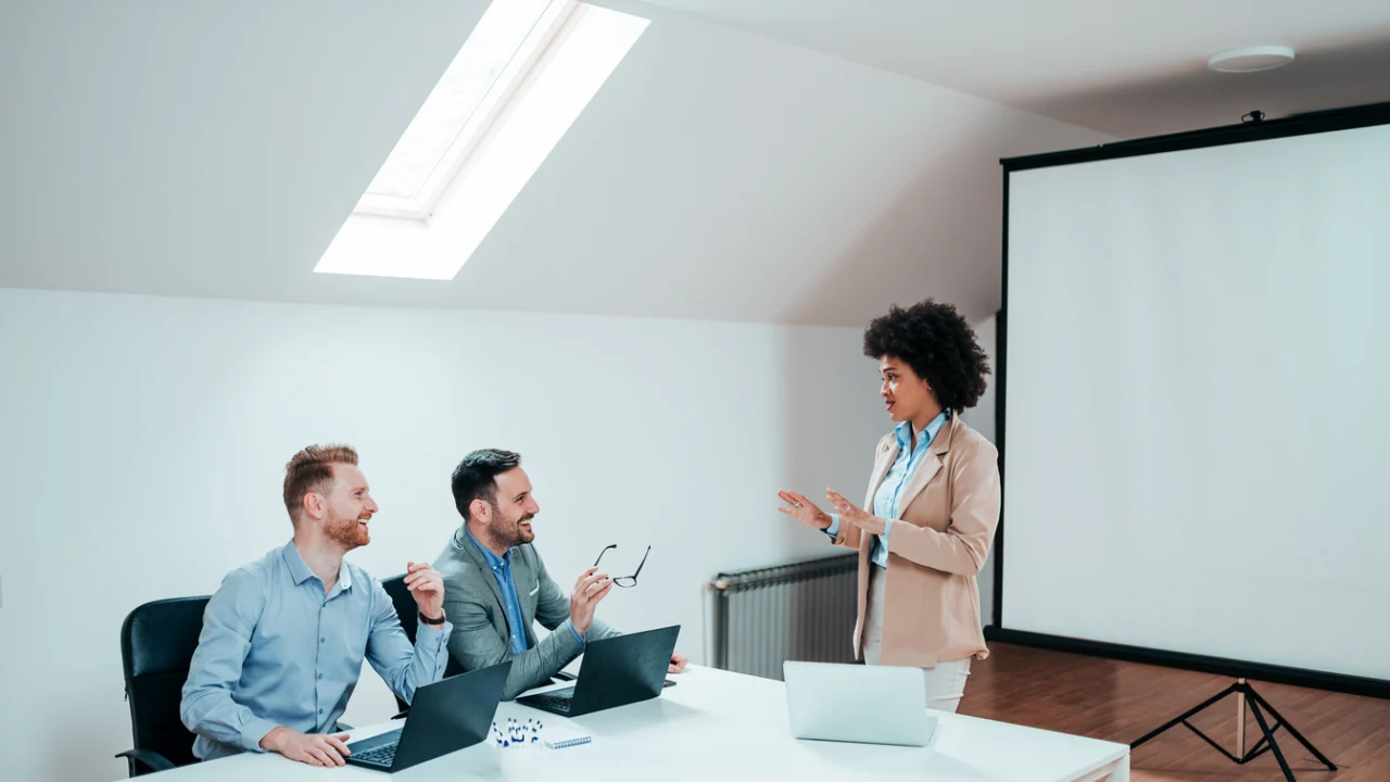 sala de reunião da prefeitura de Mirassol durante um treinamento, com gestores sentados em mesas, projetor mostrando slides sobre saúde mental