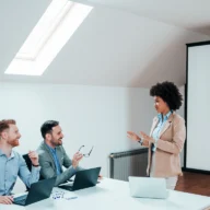 sala de reunião da prefeitura de Mirassol durante um treinamento, com gestores sentados em mesas, projetor mostrando slides sobre saúde mental