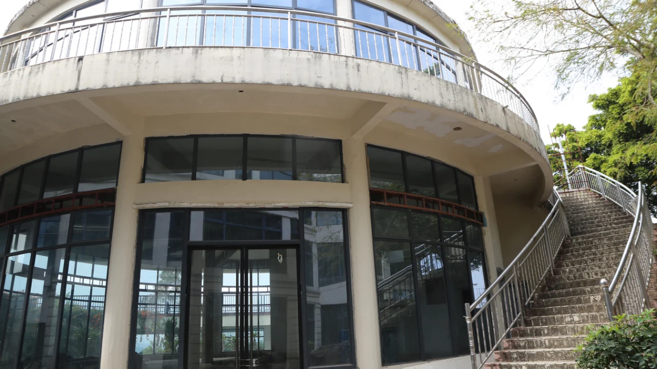 Fachada de um prédio público municipal com escadaria e portas de vidro ao entardecer