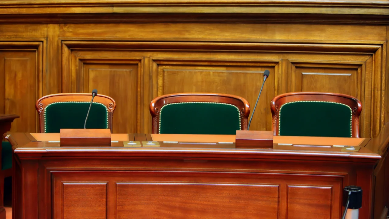 Bancada de madeira e cadeiras vazias em sala de reuniões