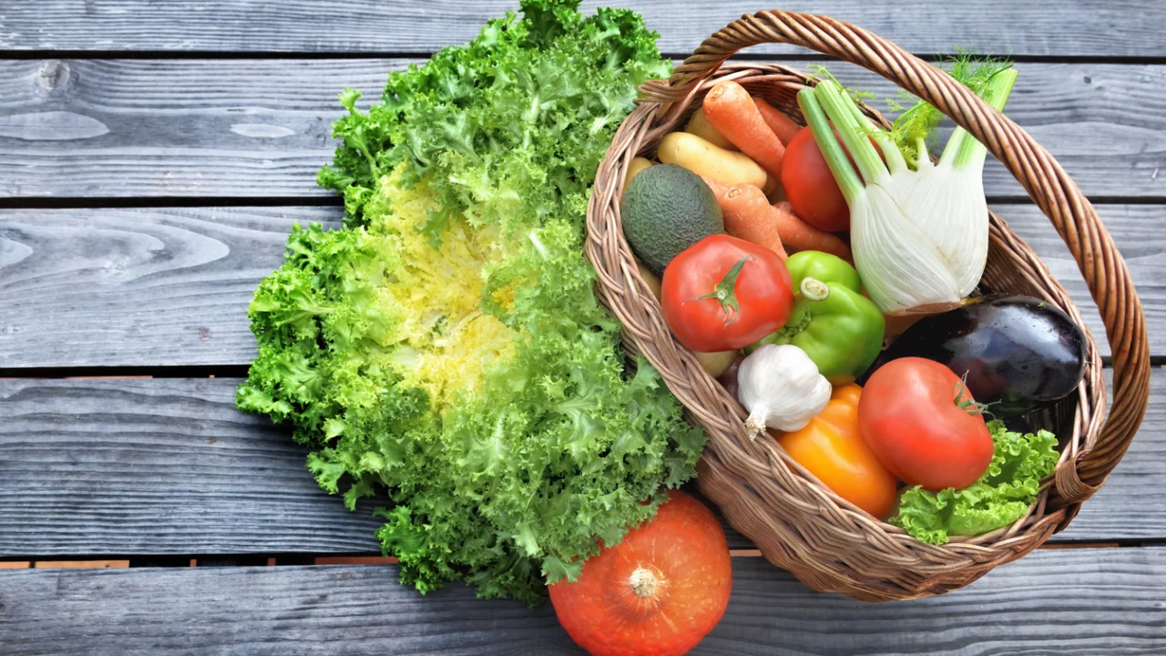 Cestas com frutas, legumes e verduras frescas sobre bancas de madeira em banco de alimentos