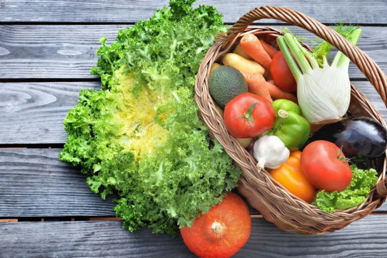 Cestas com frutas, legumes e verduras frescas sobre bancas de madeira em banco de alimentos