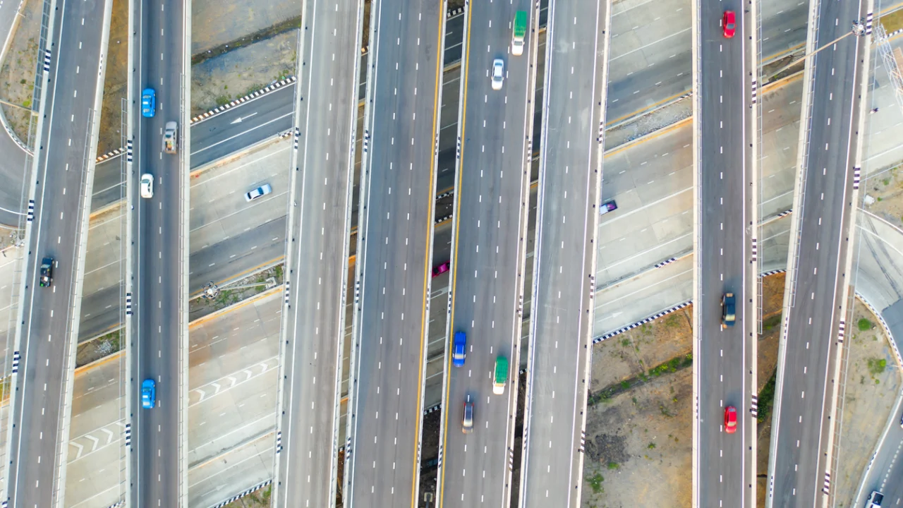 Vista aérea de avenida urbana com várias faixas e carros em movimento