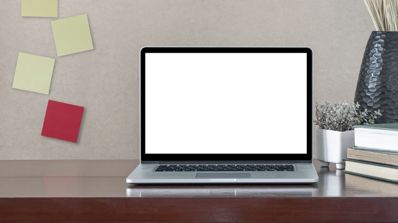 Computador portátil com tela em branco sobre mesa de trabalho.