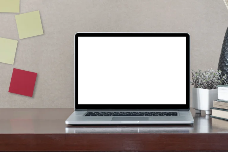 Computador portátil com tela em branco sobre mesa de trabalho.
