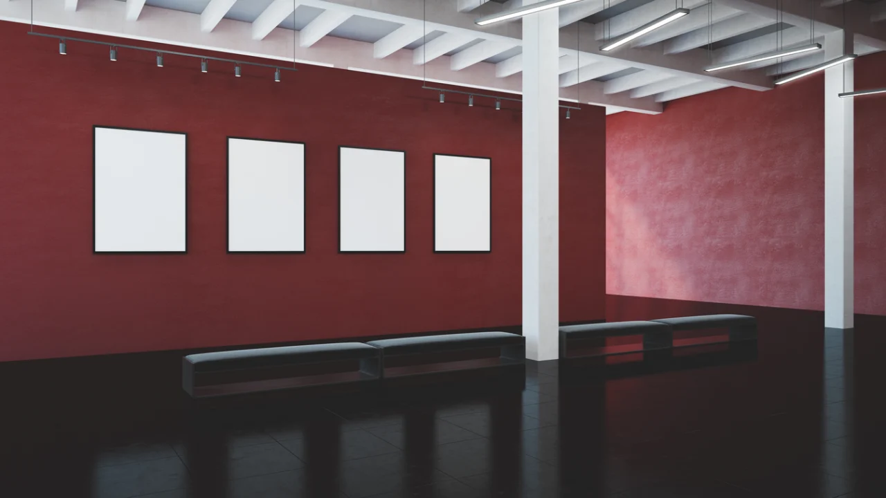 Interior de uma galeria de exposição com painéis pendurados nas paredes sob iluminação de museu