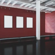 Interior de uma galeria de exposição com painéis pendurados nas paredes sob iluminação de museu