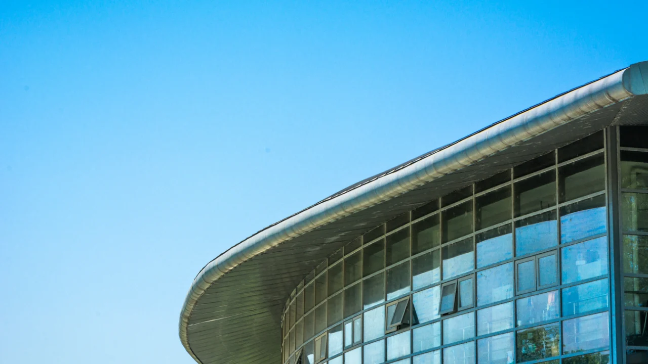Fachada de vidro e concreto de prédio público sob céu azul
