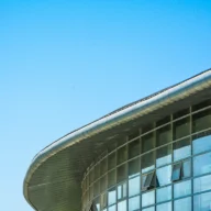 Fachada de vidro e concreto de prédio público sob céu azul
