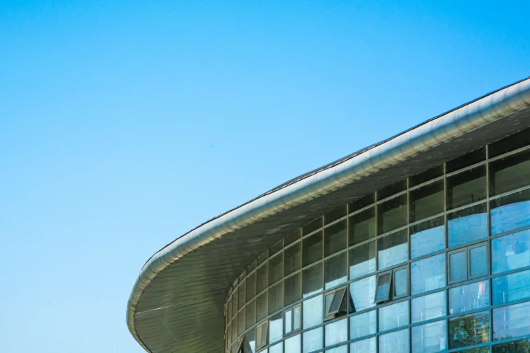 Fachada de vidro e concreto de prédio público sob céu azul