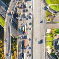 Vista aérea de um cruzamento de rodovias urbanas com trânsito intenso de carros, ônibus e caminhões em São Paulo