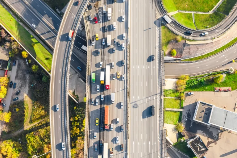 Vista aérea de um cruzamento de rodovias urbanas com trânsito intenso de carros, ônibus e caminhões em São Paulo