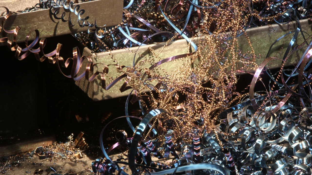 Aparas e fitas de cobre e metal acumuladas em pátio de reciclagem sob luz do dia