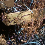 Aparas e fitas de cobre e metal acumuladas em pátio de reciclagem sob luz do dia